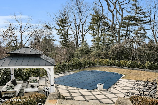 view of swimming pool with a covered pool, an outdoor hangout area, a patio, and a gazebo