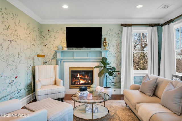 sitting room with crown molding, recessed lighting, a glass covered fireplace, and wallpapered walls