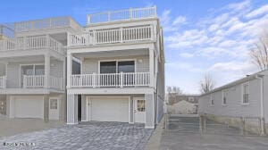 view of front of property featuring a garage, decorative driveway, and a balcony