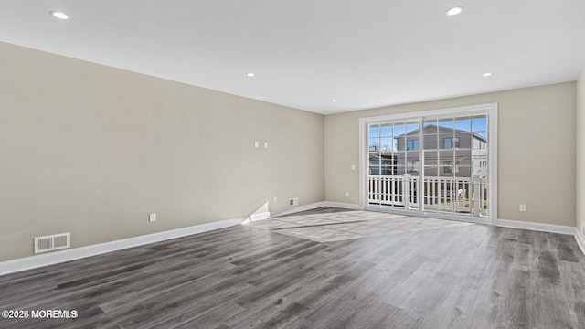 unfurnished room with recessed lighting, wood finished floors, visible vents, and baseboards