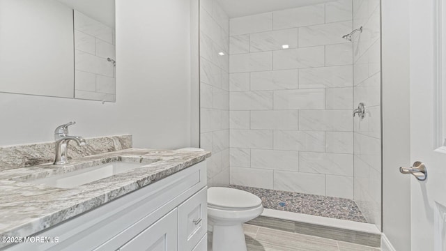 bathroom featuring toilet, a stall shower, and vanity