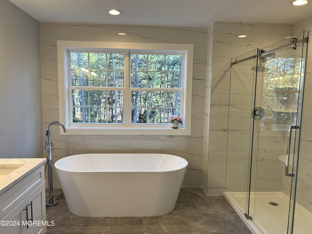 full bath with a healthy amount of sunlight, a freestanding tub, and vanity