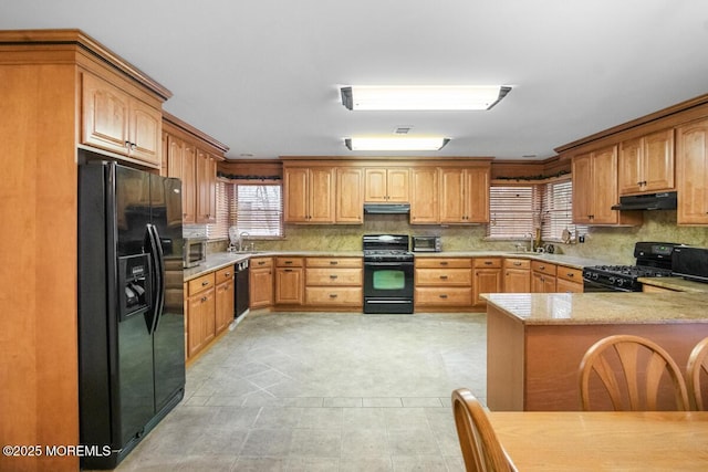 kitchen featuring black appliances, a sink, and under cabinet range hood