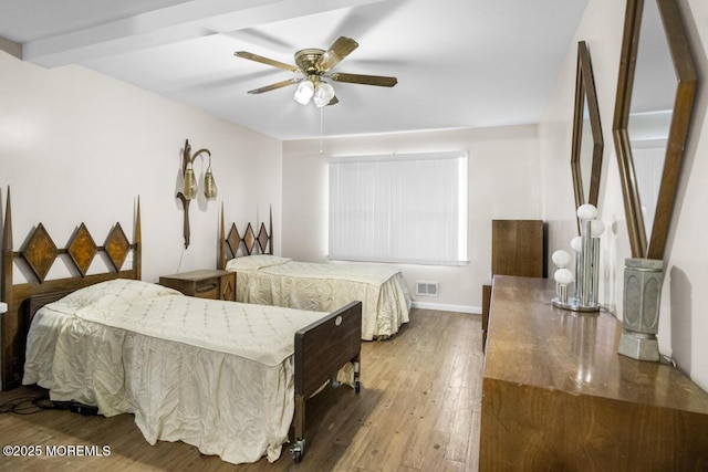 bedroom with baseboards, wood finished floors, visible vents, and a ceiling fan