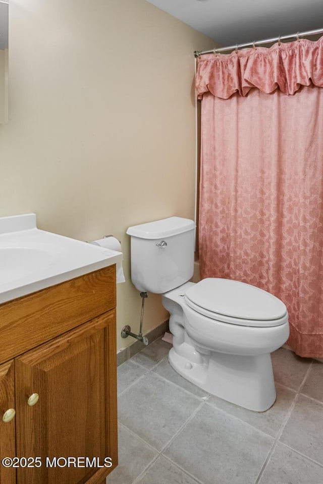 full bath featuring toilet, tile patterned floors, vanity, baseboards, and a shower with curtain