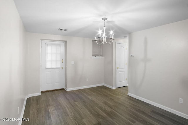 unfurnished dining area featuring dark wood-style floors, a chandelier, visible vents, and baseboards
