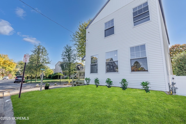 view of property exterior with fence and a yard