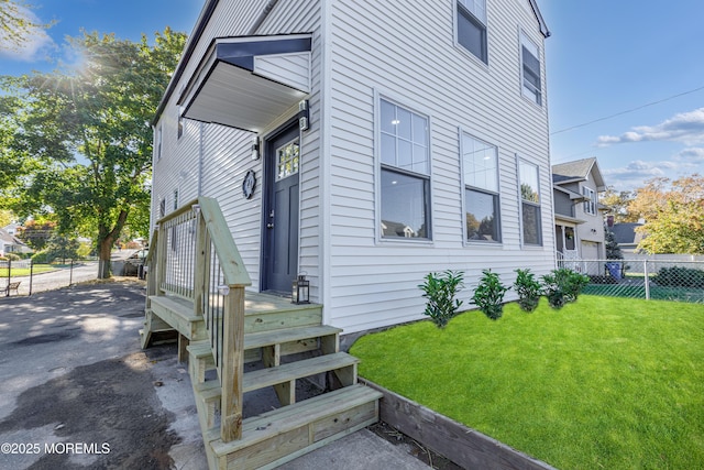 entrance to property with a lawn and fence