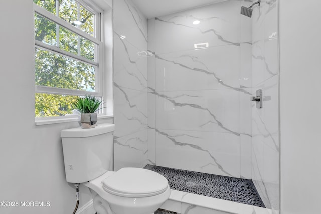 bathroom featuring a wealth of natural light, marble finish floor, a marble finish shower, and toilet