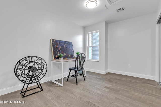 office area with visible vents, baseboards, and wood finished floors