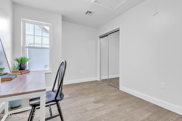 office area featuring light wood-style floors, visible vents, and baseboards