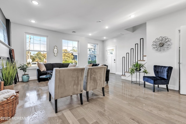 living area with recessed lighting, visible vents, light wood-style flooring, and baseboards