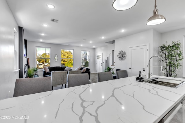 interior space featuring decorative light fixtures, visible vents, a sink, and recessed lighting