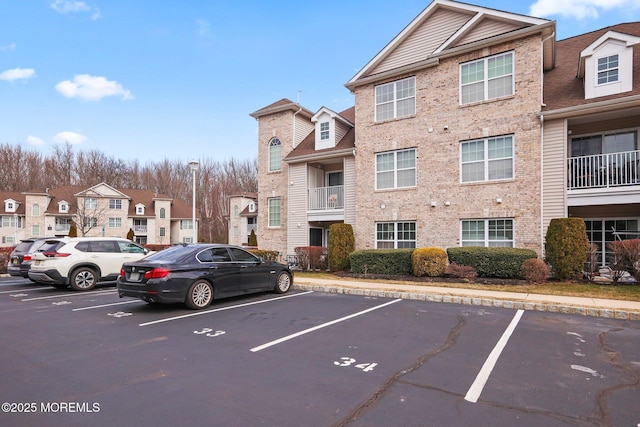 view of building exterior with uncovered parking and a residential view