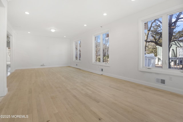 empty room with light wood-style floors, recessed lighting, visible vents, and baseboards