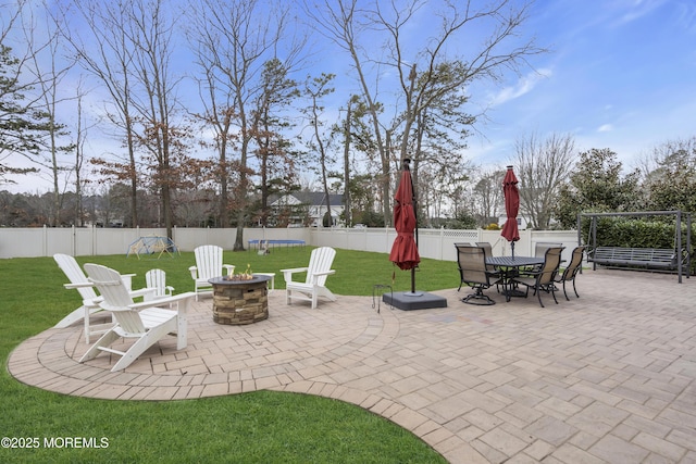 view of patio featuring fence private yard, a trampoline, and a fire pit