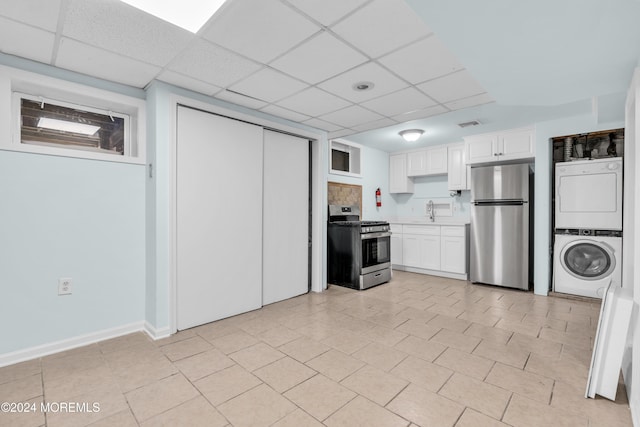 138 Summit Ave, Neptune City, NJ 07753 - kitchen with a paneled ceiling, appliances with stainless steel finishes, stacked washer / drying machine, a sink, and white cabinetry