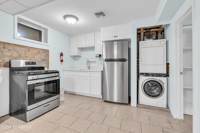 138 Summit Ave, Neptune City, NJ 07753 - kitchen featuring stacked washer and clothes dryer, light countertops, white cabinetry, a sink, and appliances with stainless steel finishes