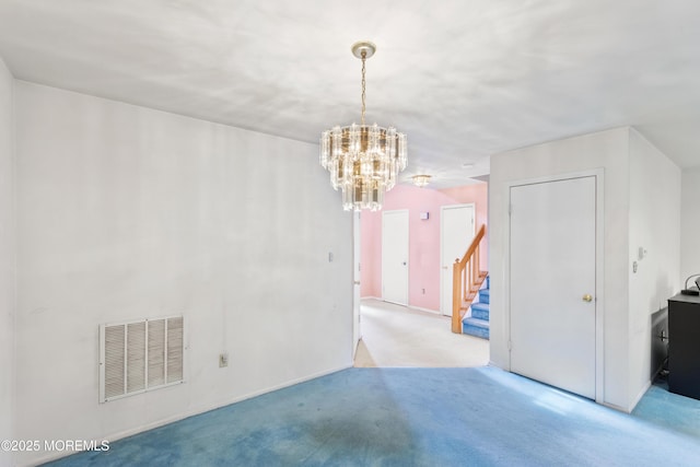 empty room featuring light carpet, stairway, visible vents, and a chandelier