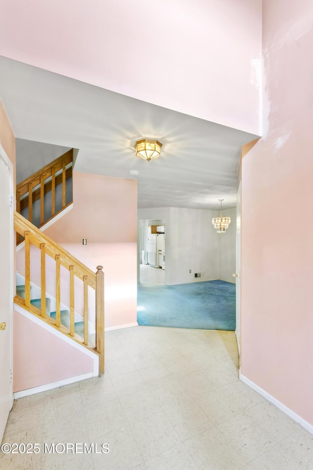 interior space featuring stairs, baseboards, a chandelier, and tile patterned floors