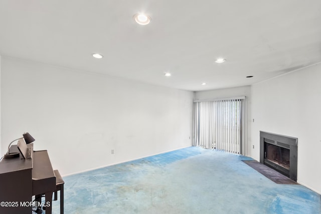 living room with carpet floors, recessed lighting, and a fireplace with flush hearth