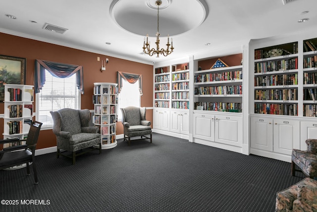 living area featuring built in shelves, a notable chandelier, visible vents, dark carpet, and ornamental molding