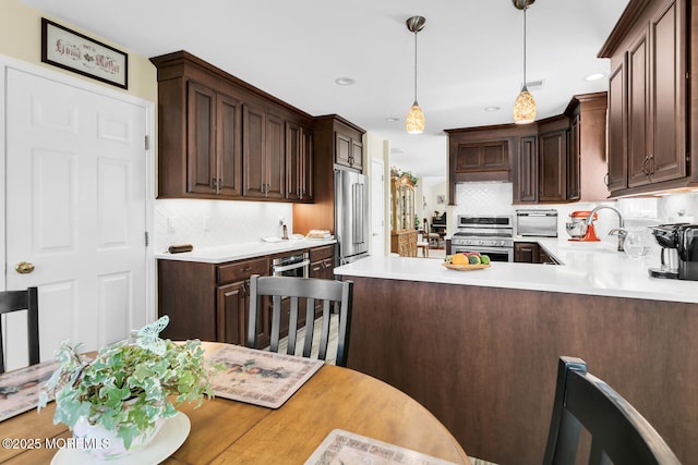 kitchen with appliances with stainless steel finishes, dark brown cabinets, a sink, and light countertops