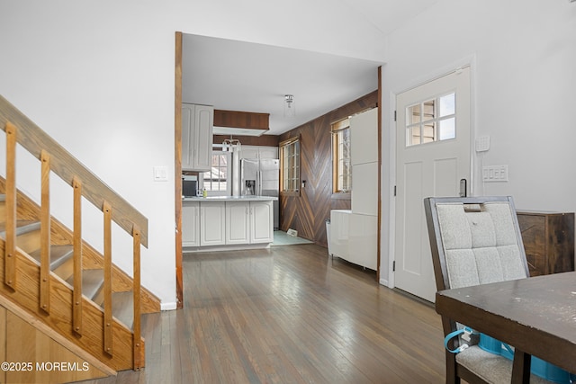 foyer featuring dark wood finished floors and stairway