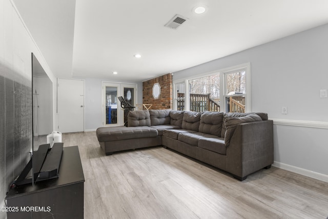 living area with light wood finished floors, recessed lighting, visible vents, and baseboards