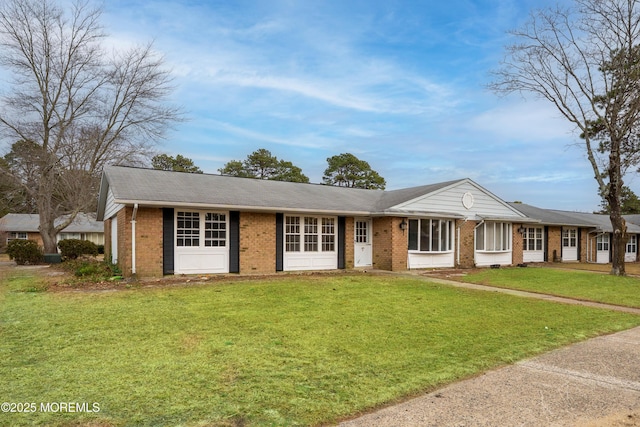 single story home with brick siding and a front yard