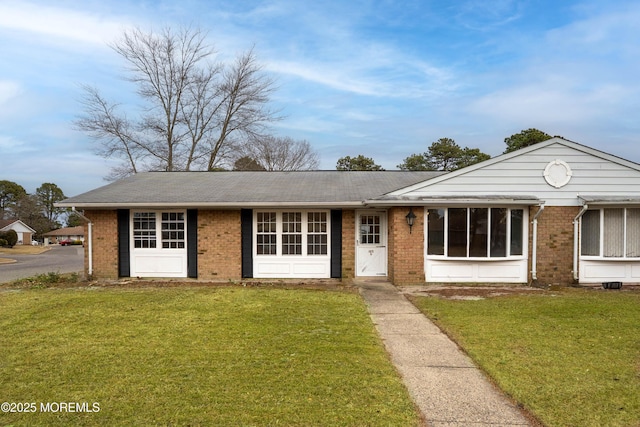 ranch-style house featuring a front lawn and brick siding