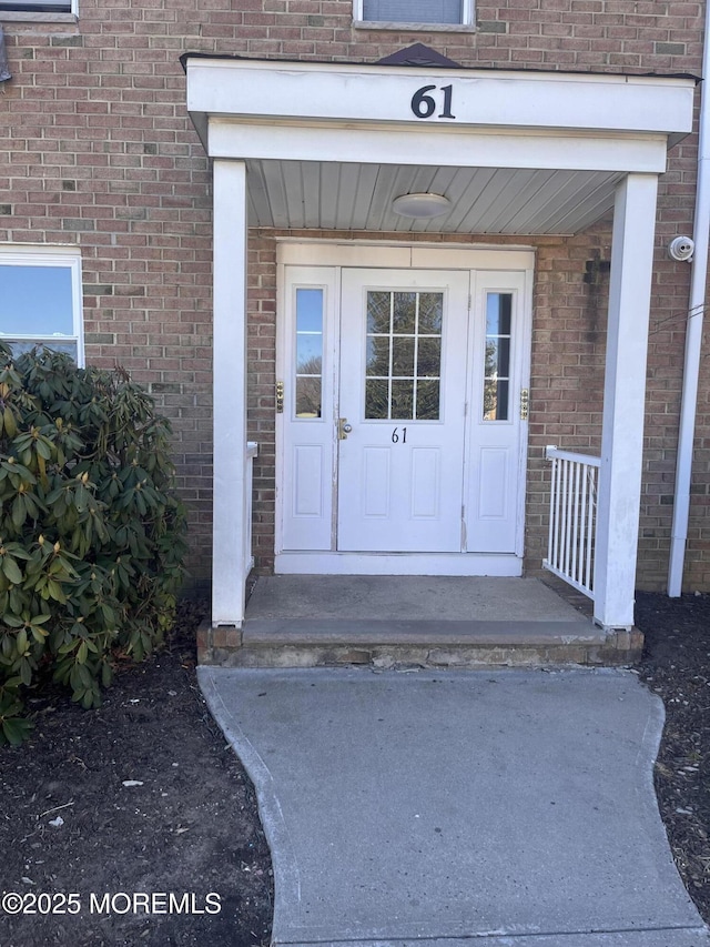 property entrance featuring brick siding