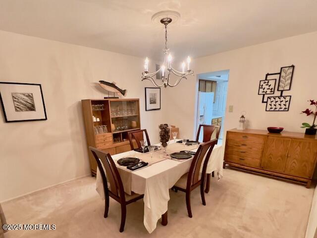 dining space featuring an inviting chandelier and light colored carpet