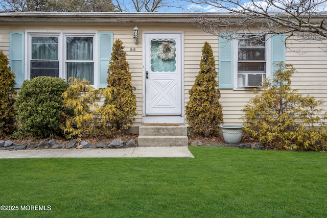 doorway to property featuring a lawn and cooling unit