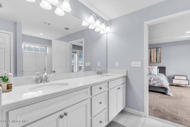 ensuite bathroom featuring visible vents, a sink, and tile patterned floors