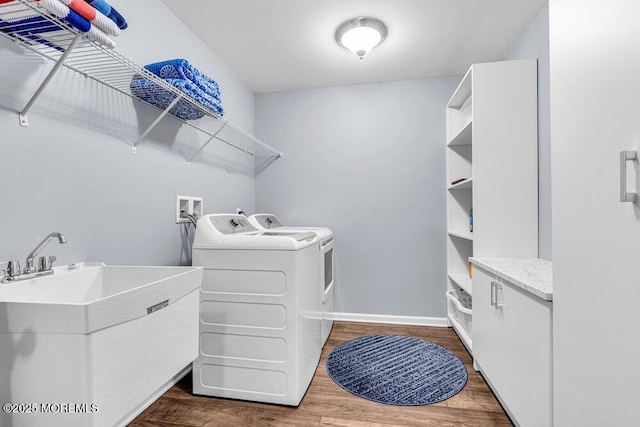 washroom with laundry area, a sink, baseboards, independent washer and dryer, and dark wood finished floors