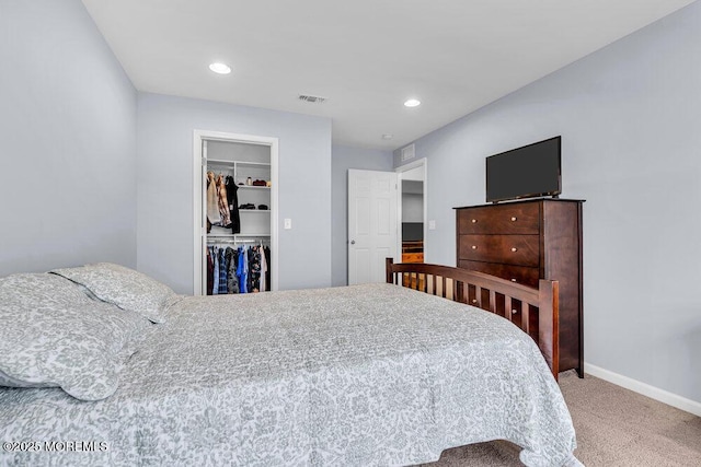 carpeted bedroom with a closet, recessed lighting, a walk in closet, and baseboards