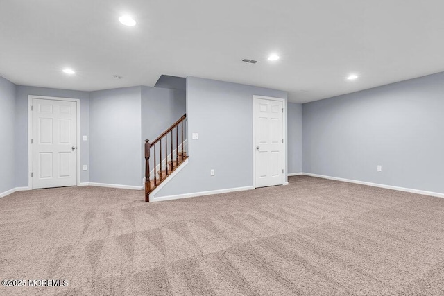 finished basement featuring carpet floors, stairs, visible vents, and recessed lighting