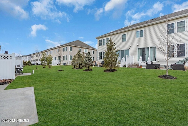 back of property with entry steps, a lawn, and a residential view