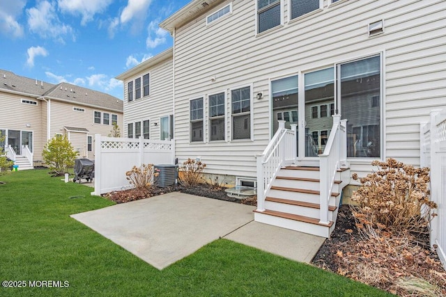 back of house featuring central AC, a lawn, a patio area, and fence