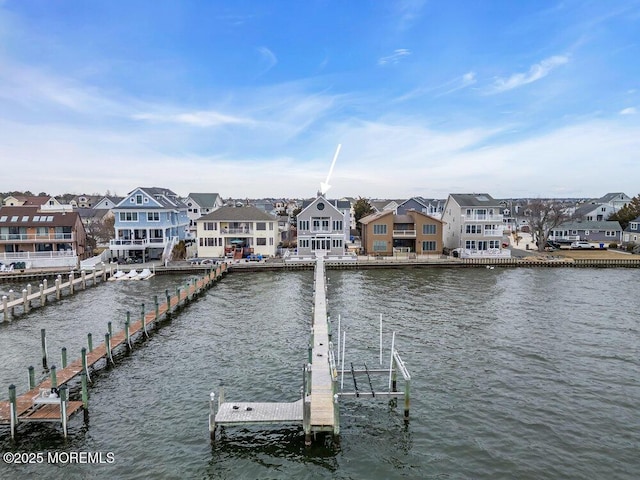 view of dock with a water view and a residential view