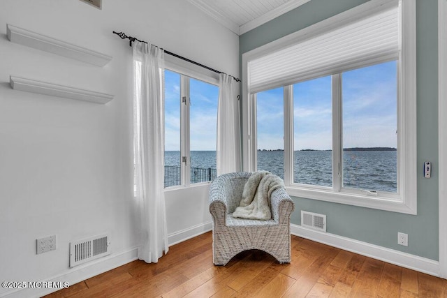 living area featuring baseboards, visible vents, a water view, and hardwood / wood-style floors