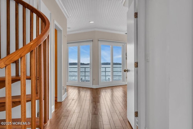 interior space featuring baseboards, stairs, ornamental molding, and wood finished floors