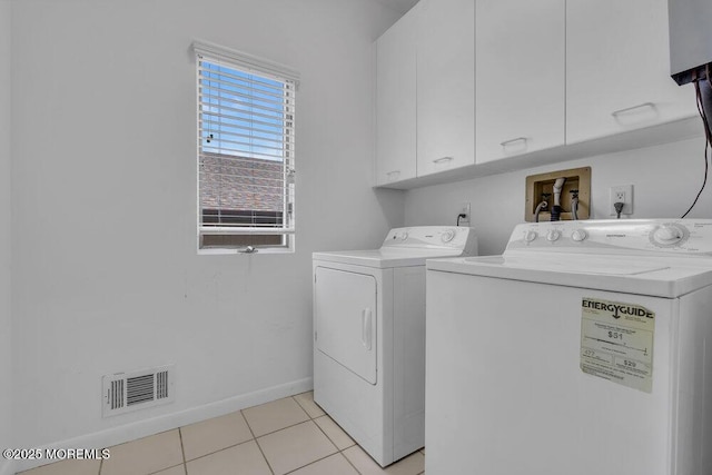 laundry room with washer and clothes dryer, visible vents, cabinet space, light tile patterned flooring, and baseboards