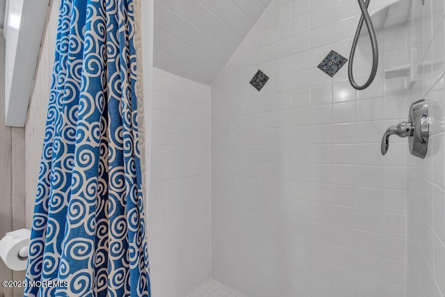 full bathroom with lofted ceiling and a tile shower