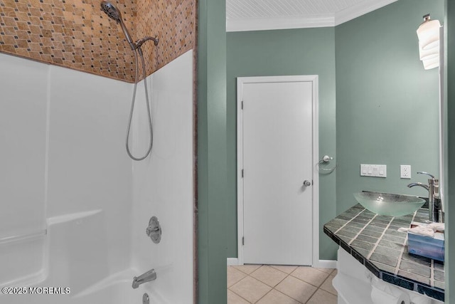 bathroom with washtub / shower combination, ornamental molding, a sink, tile patterned flooring, and baseboards