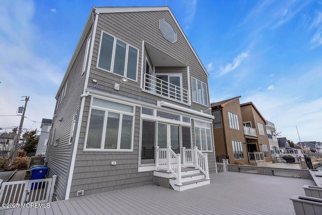 back of property featuring a sunroom and a deck