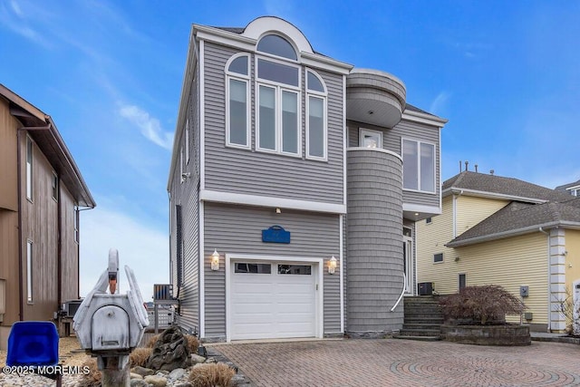 view of front facade featuring decorative driveway and an attached garage