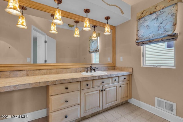 bathroom featuring visible vents, vanity, and baseboards