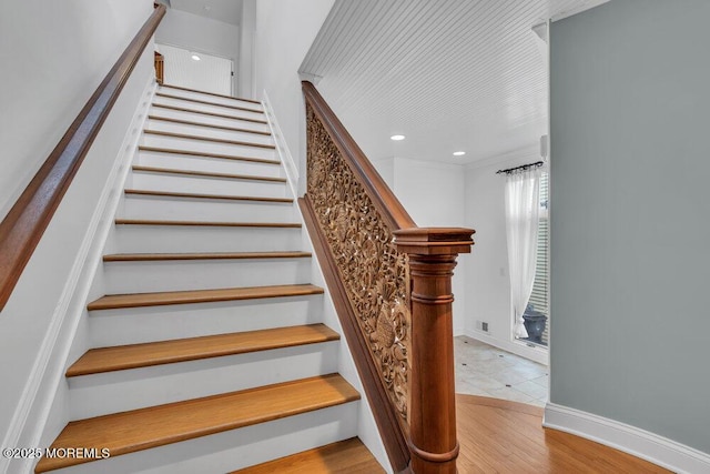 stairway with recessed lighting, baseboards, and wood finished floors